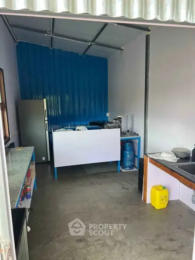Compact kitchen with industrial design featuring gas stove and stainless steel appliances.
