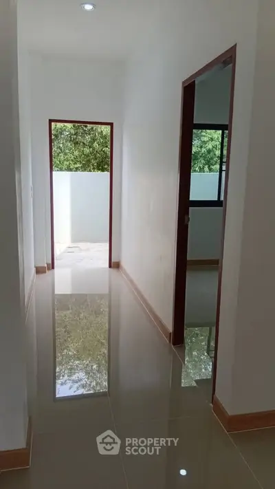 Bright hallway with glossy tiled floor and natural light