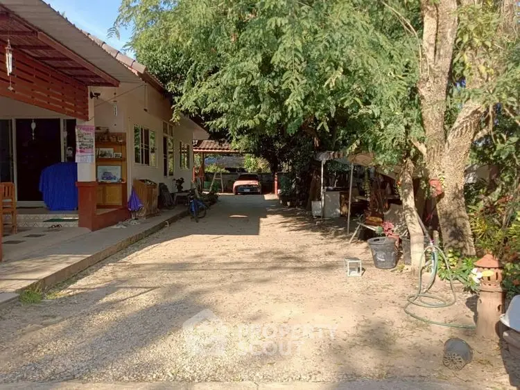 Charming rural property with spacious driveway and lush greenery.