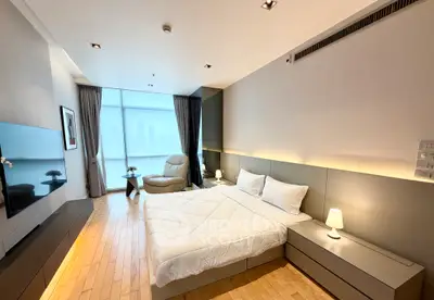 Luxurious modern bedroom with city view, featuring sleek furniture and ambient lighting.