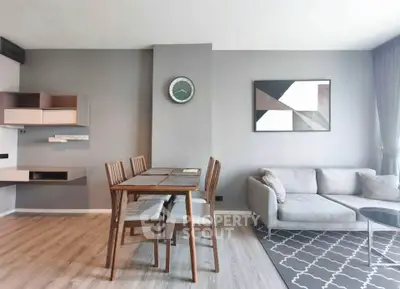 Modern living room with stylish decor, featuring a cozy sofa, dining table, and contemporary wall art.
