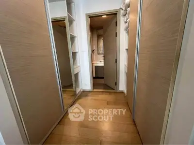 Spacious walk-in closet with wooden flooring and ample storage space.