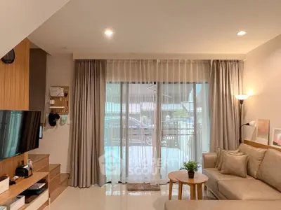 Modern living room with elegant decor, large windows, and cozy seating area, perfect for relaxation and entertainment.