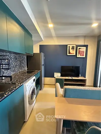 Modern open-layout kitchen and living area with stylish decor and appliances