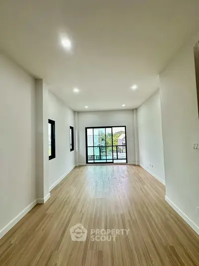 Spacious modern living room with large windows and wooden flooring