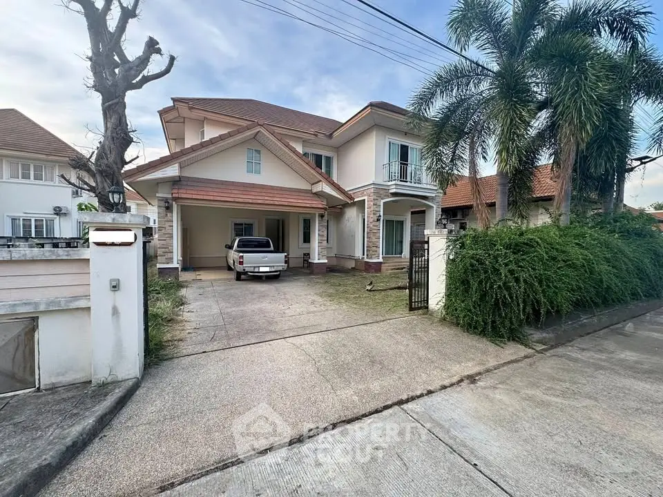 Charming two-story house with driveway and lush greenery in a serene neighborhood.