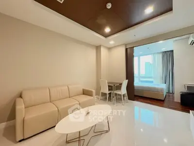 Modern open-plan living room with beige sofa and dining area, leading to a bedroom with city view.