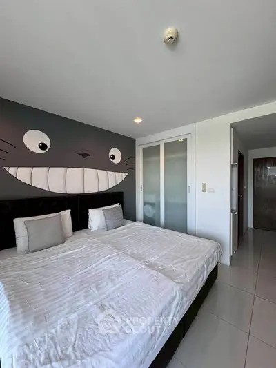 Charming bedroom with playful wall art and modern sliding closet doors, perfect for a cozy retreat.
