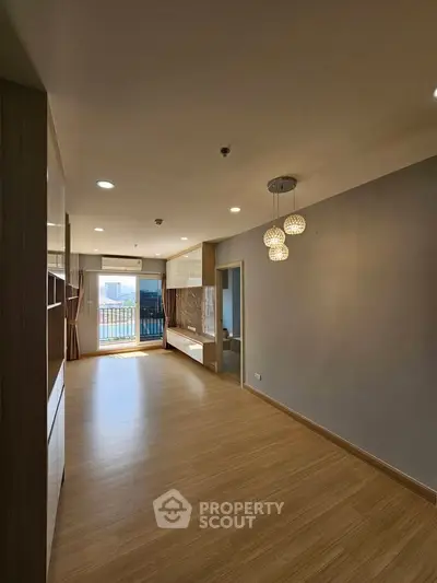 Spacious modern living room with wooden flooring and balcony view
