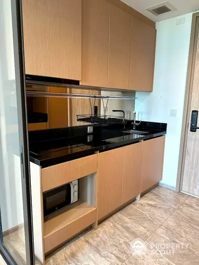 Modern kitchen with sleek cabinetry and black countertops in a stylish apartment.