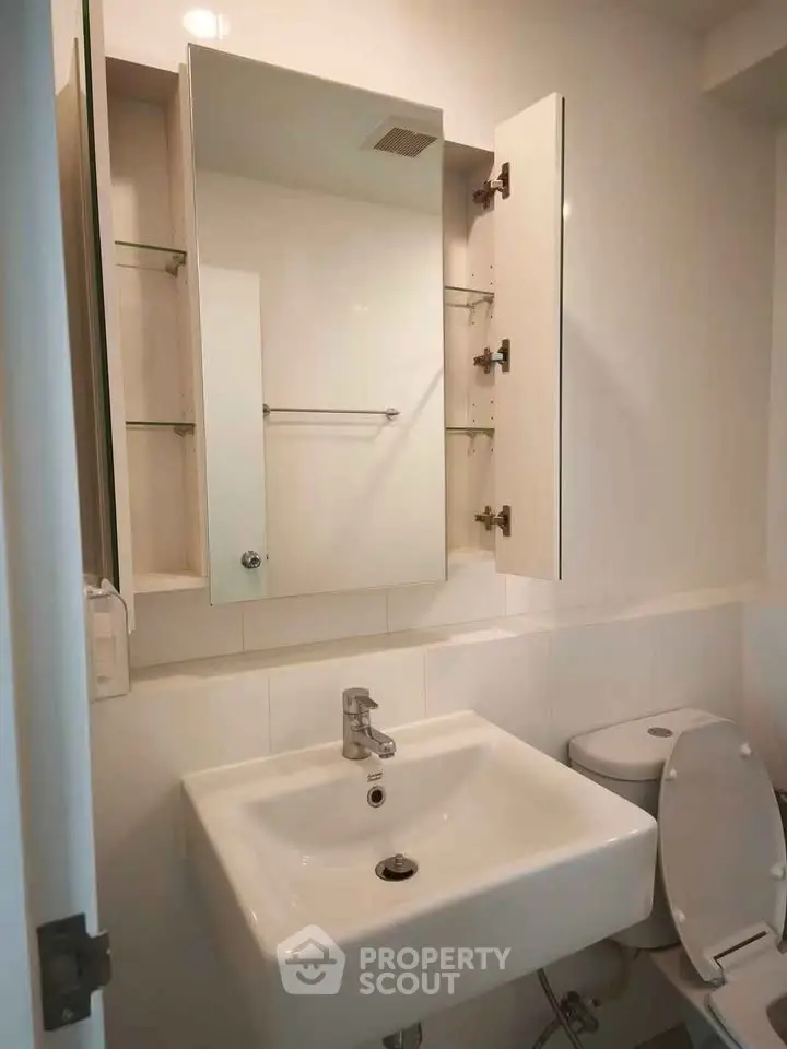 Modern bathroom with sleek sink and mirrored cabinet in a contemporary apartment.
