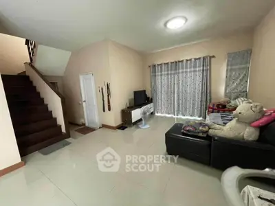 Spacious living room with modern decor and staircase, perfect for family gatherings.