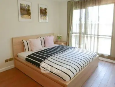Spacious bedroom with large window and stylish decor