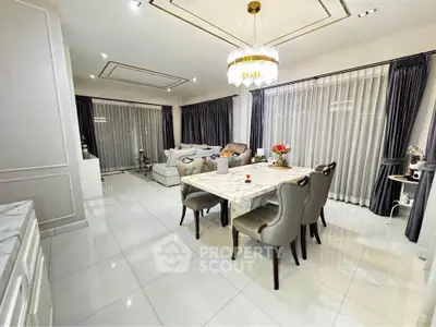 Luxurious open-plan living and dining area with elegant decor and chandelier lighting.