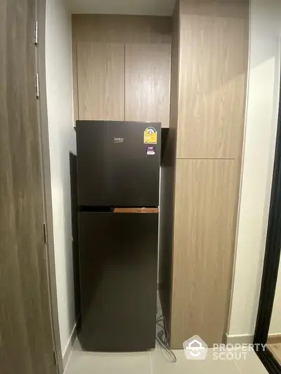 Modern kitchen with sleek black fridge and wooden cabinetry