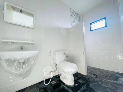 Modern bathroom with white tiles and sleek fixtures in a contemporary home.
