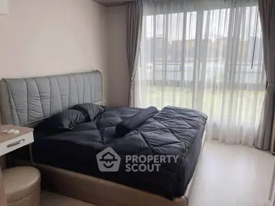 Spacious bedroom with large window and modern decor