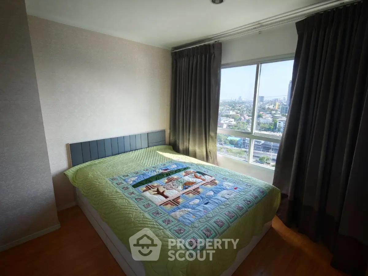 Cozy bedroom with large window offering stunning city views, featuring a comfortable bed and elegant curtains.