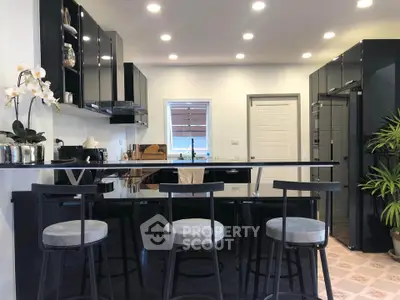 Modern kitchen with sleek black cabinets and stylish bar seating