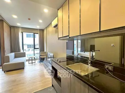 Modern open-layout living room with sleek kitchen, large windows, and stylish furnishings.