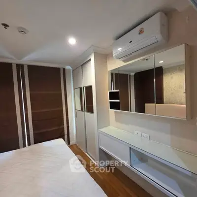 Modern bedroom with air conditioning and mirrored wardrobe in a stylish apartment.