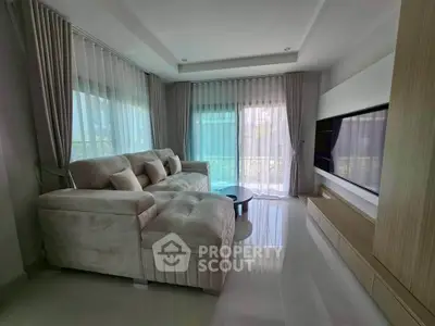 Spacious living room with plush sectional sofa and large windows for natural light.
