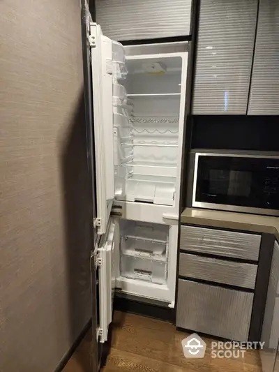 Modern kitchen with built-in fridge and microwave in sleek cabinetry