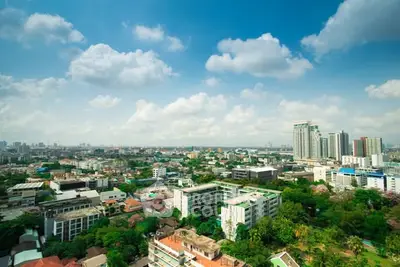Stunning cityscape view with lush greenery and modern buildings under a clear blue sky.