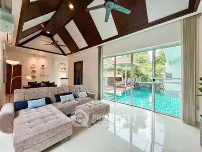 Luxurious living room with pool view, modern ceiling design, and plush seating in a serene home setting.