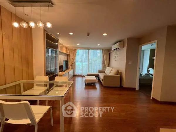 Spacious living room with modern furniture and wooden flooring, perfect for family gatherings.