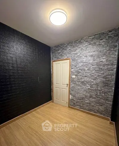Modern empty room with stylish textured walls and wooden flooring