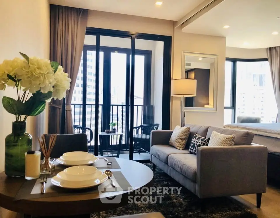Modern open-plan living room with cozy sofa and dining area, featuring large windows and city view.
