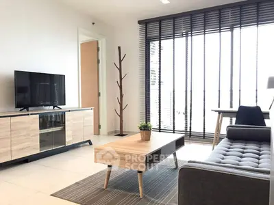 Modern living room with stylish furniture and large windows offering ample natural light.