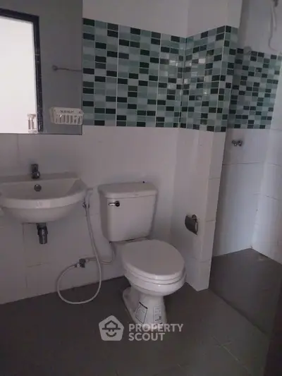 Modern bathroom with stylish tile accents and compact fixtures