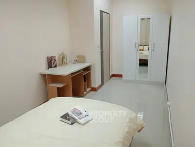 Cozy bedroom with modern wardrobe and study desk, perfect for comfortable living.
