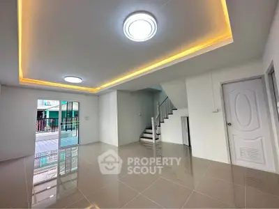 Modern interior with sleek staircase and glossy tiled floor, featuring ambient ceiling lighting.