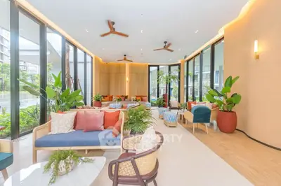 Luxurious modern living room with large windows, stylish furniture, and lush greenery, offering a serene ambiance.
