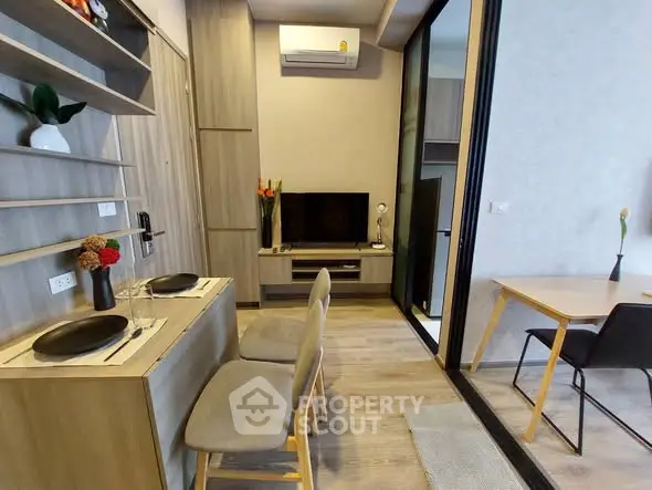 Modern living room with stylish decor and dining area in a compact apartment.