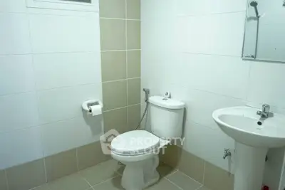 Modern bathroom with white fixtures and tiled walls