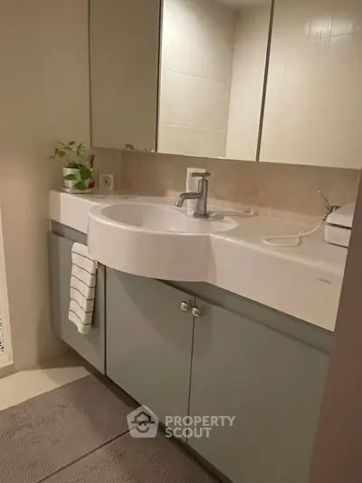 Modern bathroom with sleek vanity and large mirror, perfect for contemporary living.
