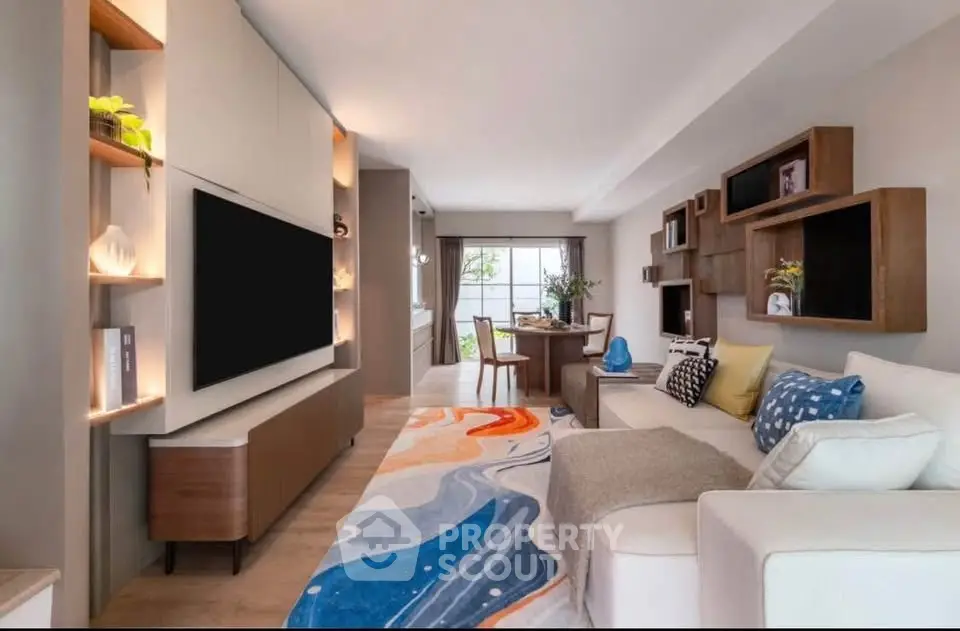 Stylish living room with modern decor and vibrant rug in a cozy apartment.