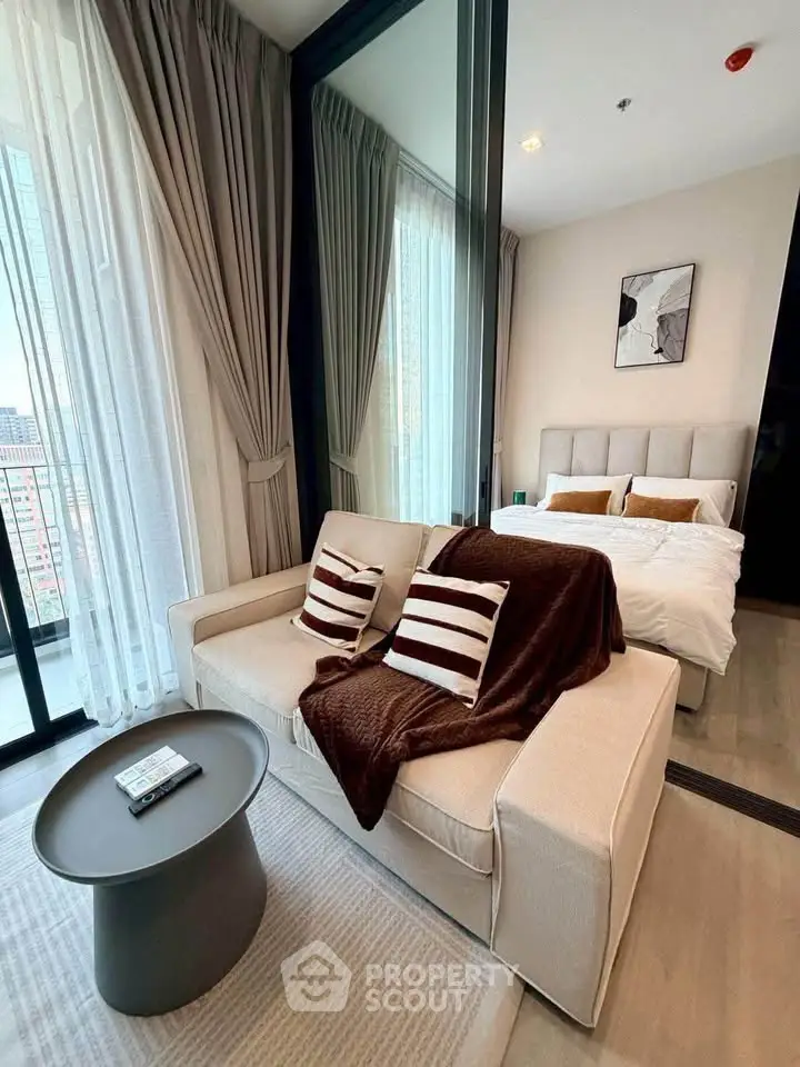 Modern studio apartment with cozy living area and stylish bedroom, featuring floor-to-ceiling windows and elegant decor.