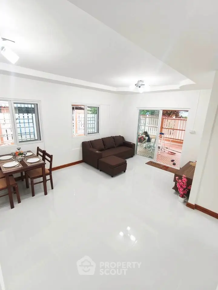 Spacious living room with modern furniture and access to a cozy balcony, perfect for relaxation.