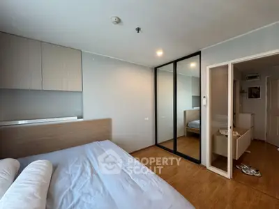 Modern bedroom with mirrored closet and wooden flooring