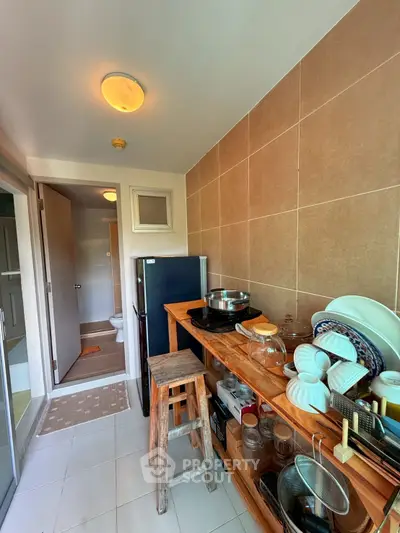 Cozy kitchen with wooden shelves and modern appliances in a compact layout.