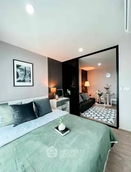 Modern bedroom with stylish decor and adjacent living area in open layout apartment.