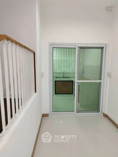Modern interior with sleek kitchen and sliding glass door, perfect for contemporary living.