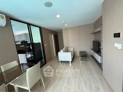 Modern living room with sleek furniture and open kitchen layout in a stylish apartment.
