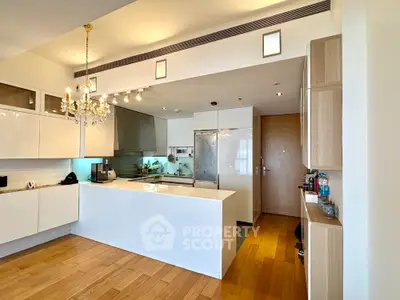 Modern kitchen with sleek white cabinets and elegant chandelier lighting