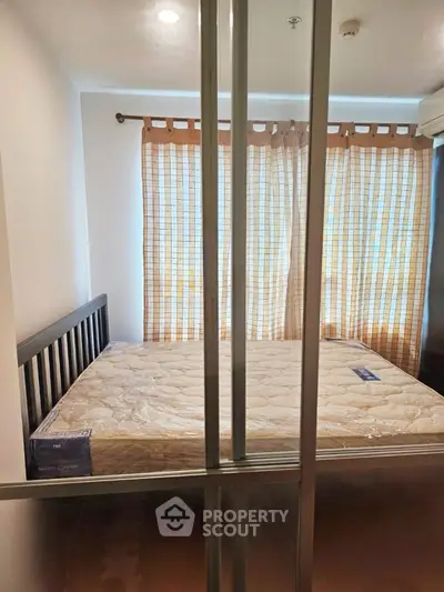 Cozy bedroom with large window and natural light, featuring a comfortable bed and modern decor.